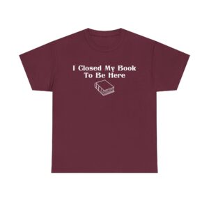 T-shirt with white text that says "I Closed My Book To Be Here" and a simple white graphic of a closed book below the text